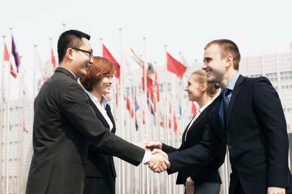 Four Smiling Business People Meeting And Shaking Hands Outdoors, Beijing